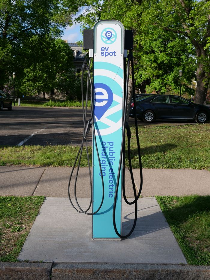About A public EV charging station located outdoors in a city park during the daytime.
